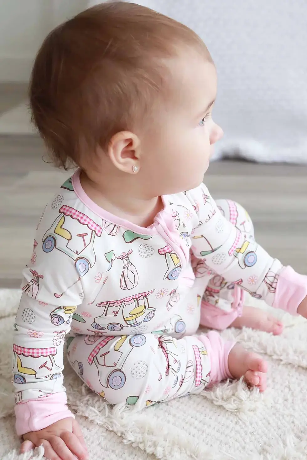 Baby wearing pink golf romper