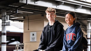 Two young people smiling at a train station