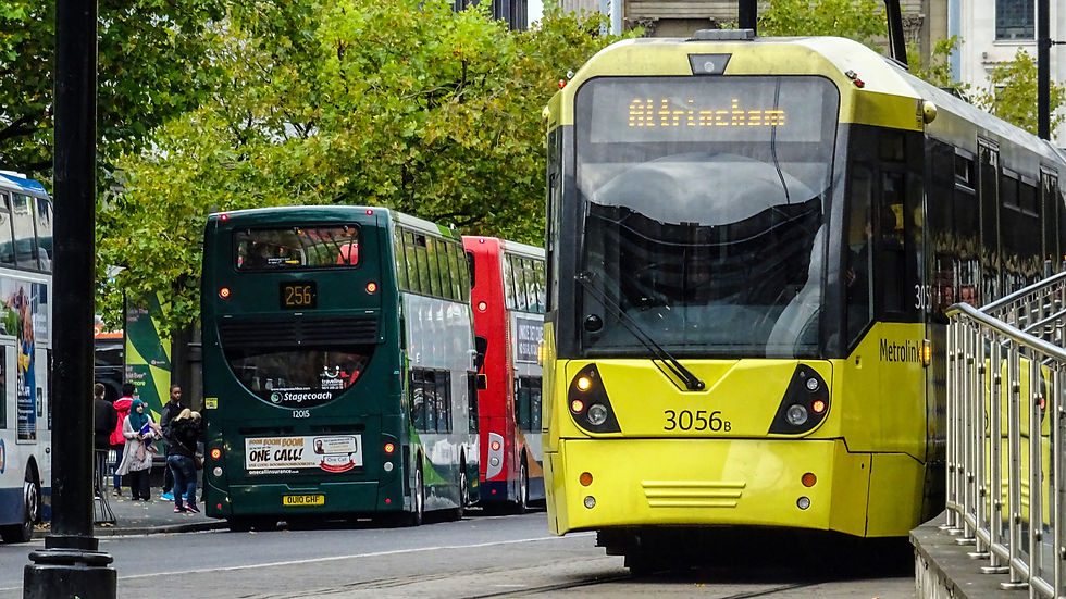 Manchester Metrolink Tram travellng to Altrincham, with a bus in the background