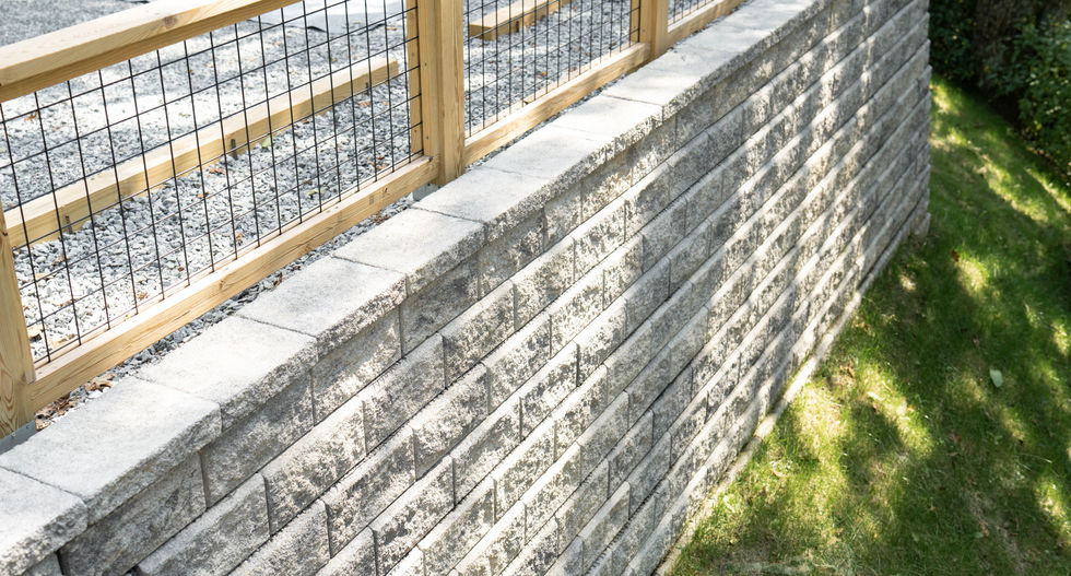 Elevated retaining wall with wood fence by Arrow Works in Spruce Pine NC