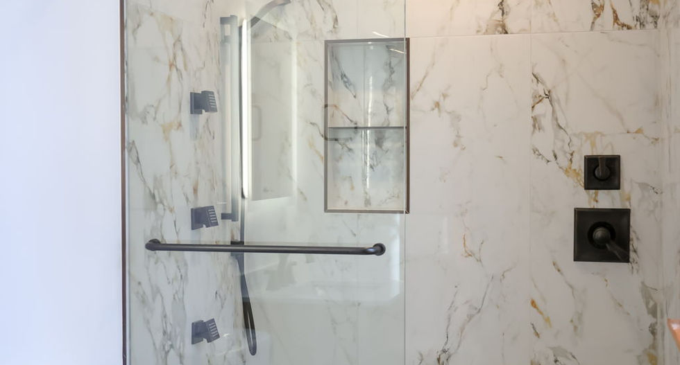 Walk-in shower by Arrow Works in Boone NC High Country with marble tile and black fixtures