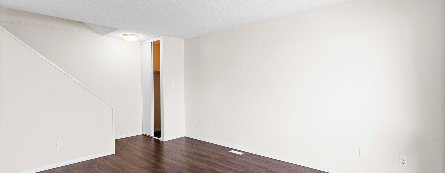 Finished basement with white walls and wood-look flooring.