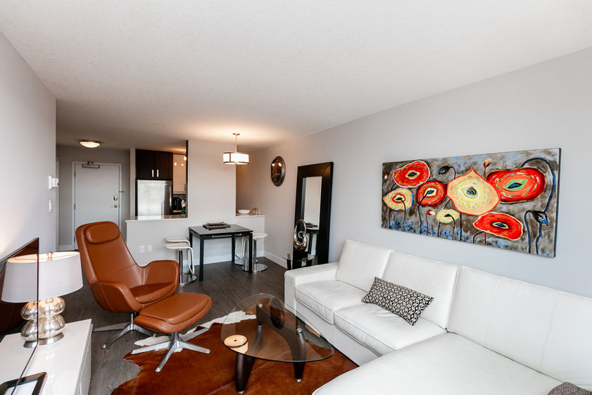 MISSAO Apartments -  Living room with white couch and brown chair.