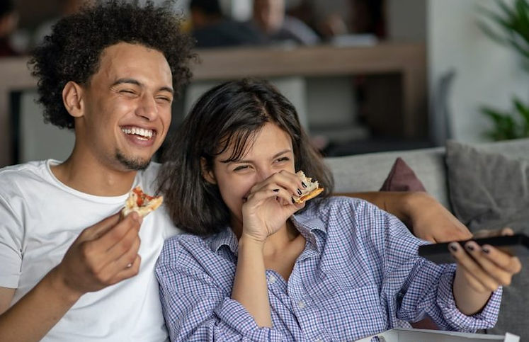 Happy-couple-watching-tv-while-eating-pizza-min-p958fsv3l1kcsrdt2qx2g09o7nm3mso2gezxolnylg