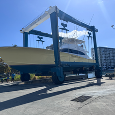 Sport-fishing yacht suspended in a Merritt's travel lift at a marina