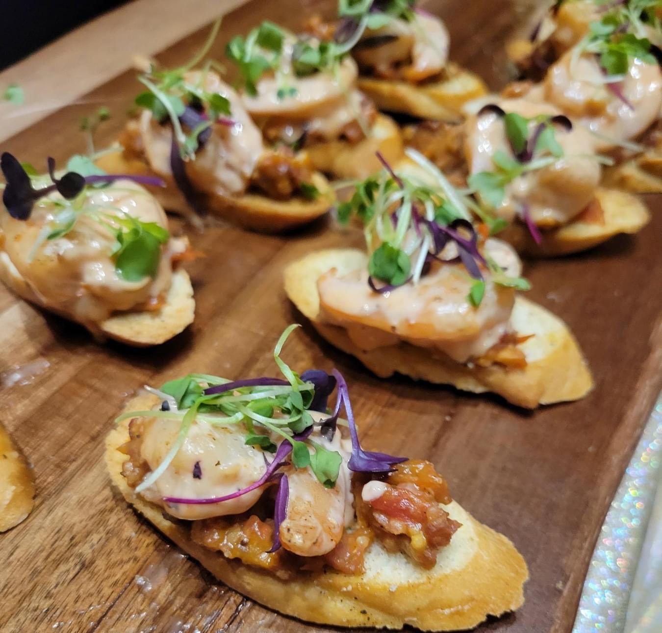 Close-up of elegant gourmet holiday appetizers served on a rustic wooden platter.