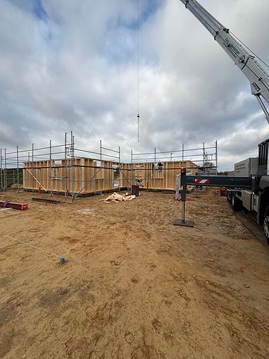 Mobilkran bei der Errichtung eines Holzrahmenbaus auf einer Baustelle