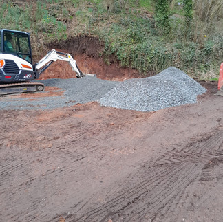 mini digger levelling out hardcore on a large patch of earth
