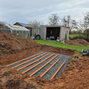 soakaway pipes being laid in trench