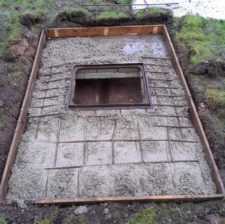 An old manhole that needs updating showing the wire grid and uneven surface