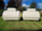two large cream septic tanks sitting side by side on a lawn