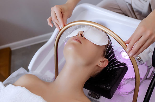 Close-up of a woman receiving a Japanese head spa treatment, relaxing with eye pads and wa