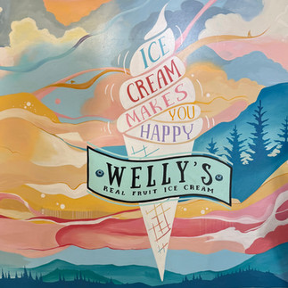 sign for Welly's Ice Cream that shows a cone of ice cream on a pastel background