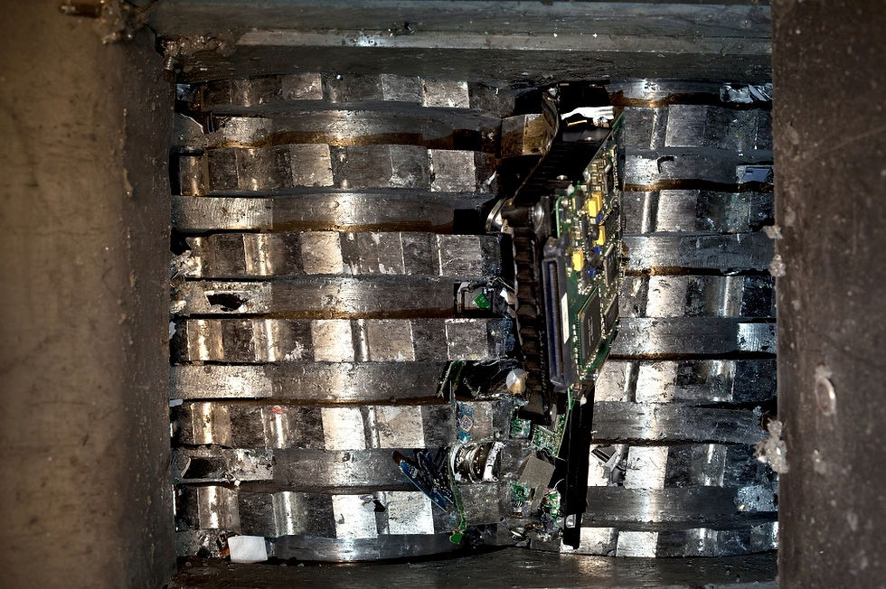 Eye-level view of a hard drive being shredded by industrial machinery