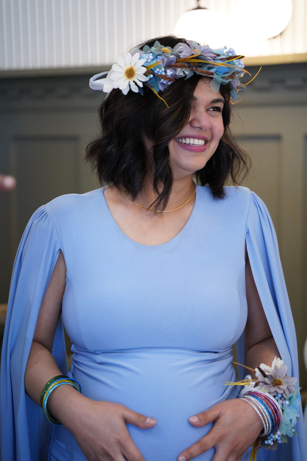 Smiling pregnant woman in blue dress and flower crown