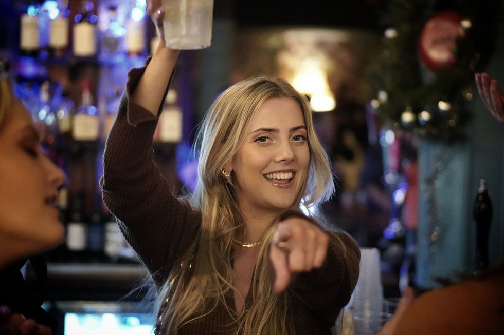 Bartender playfully points, mixing drink