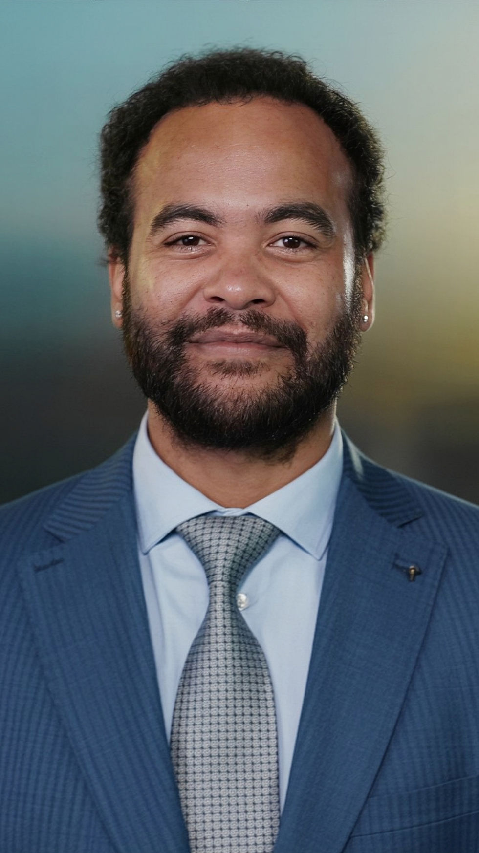 Headshot of a smiling man in a suit