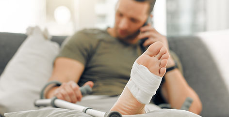 home-man-injury-with-broken-foot-bandage-inflammation-rehabilitation-with-crutch-closeup-a
