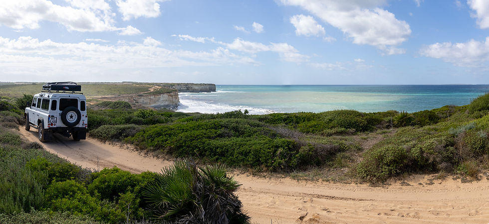 Land Rover Defender Camper steht an Abbruchkante in Sardinien am Meer