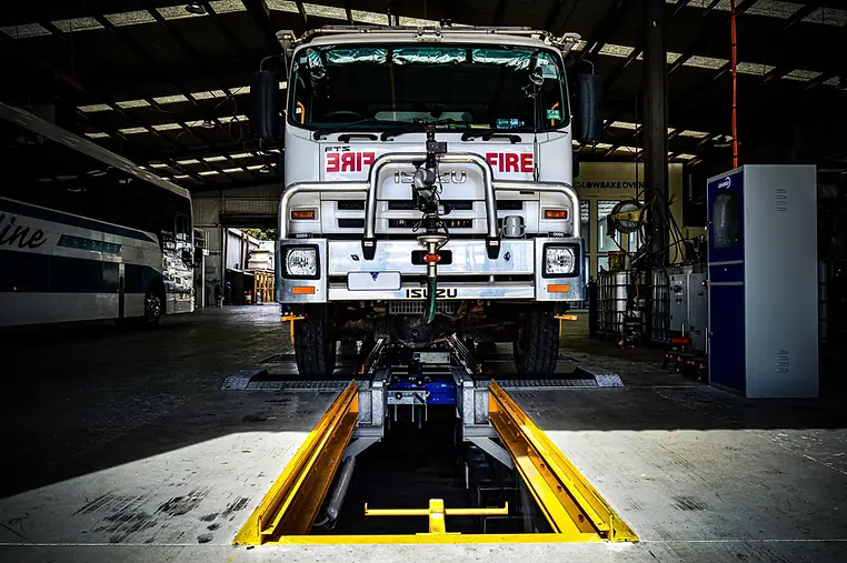 A fire-rescue Izuzu truck undergoing maintenance in one of Truckrite’s wheel inspection bays for brake testing.