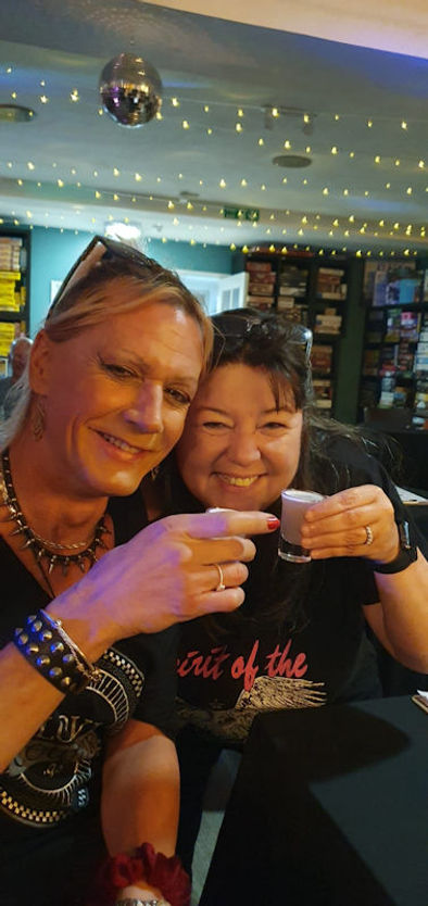 Two Queer and Now members holding their shot glasses together