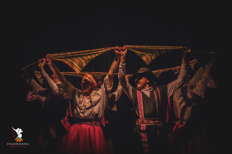 Fotografía de un grupo de bailarines, portando vestimenta campesina durante la obra 'Relatos Mágicos' en el Teatro Barajas.