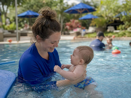 Mother holding baby in swimming pool