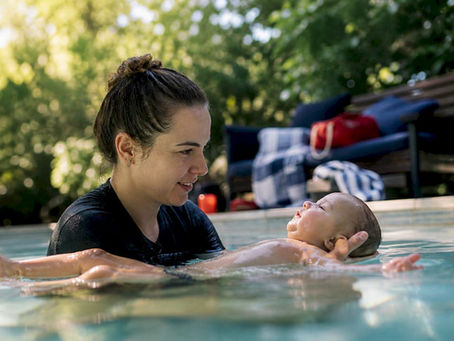 Parent supporting infant survival float in pool