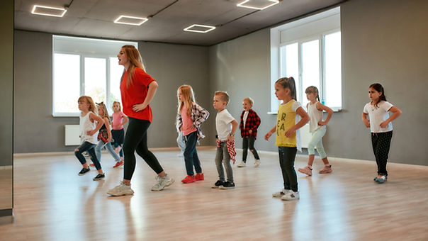 Group of little boys and girls dancing while having choreography class in the dance studio