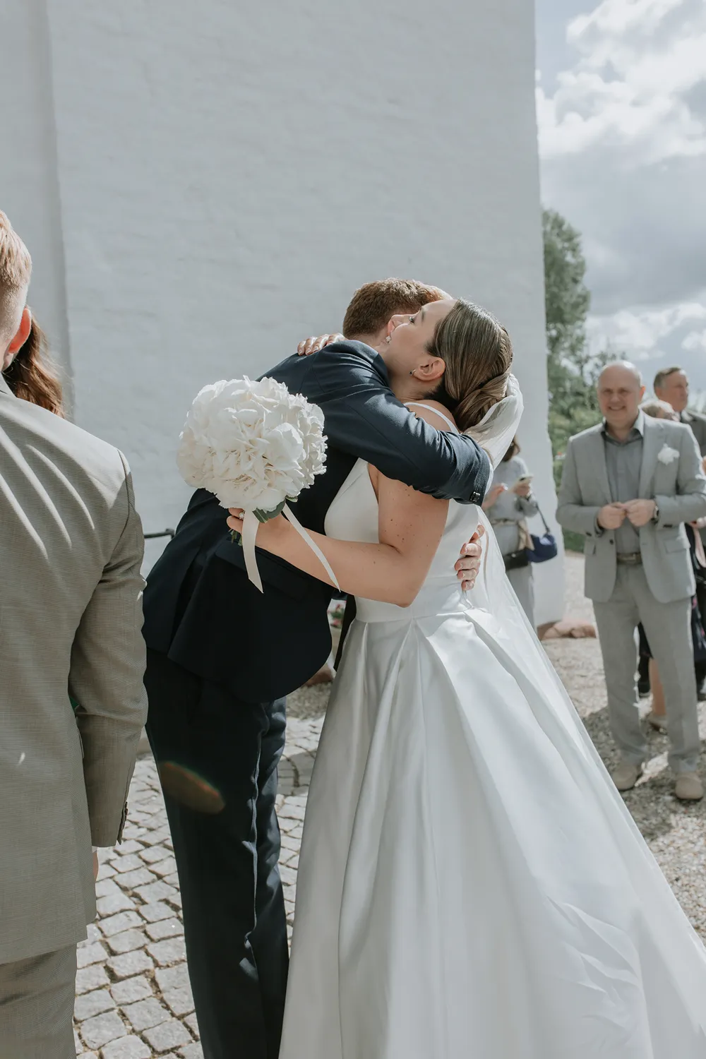 Newlyweds celebrating outside church at Holckenhavn Slot wedding