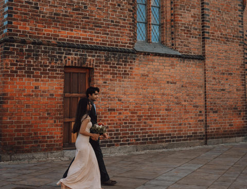 Elegant bride walking beside St. Knuds Kirke in Odense during classic Danish wedding