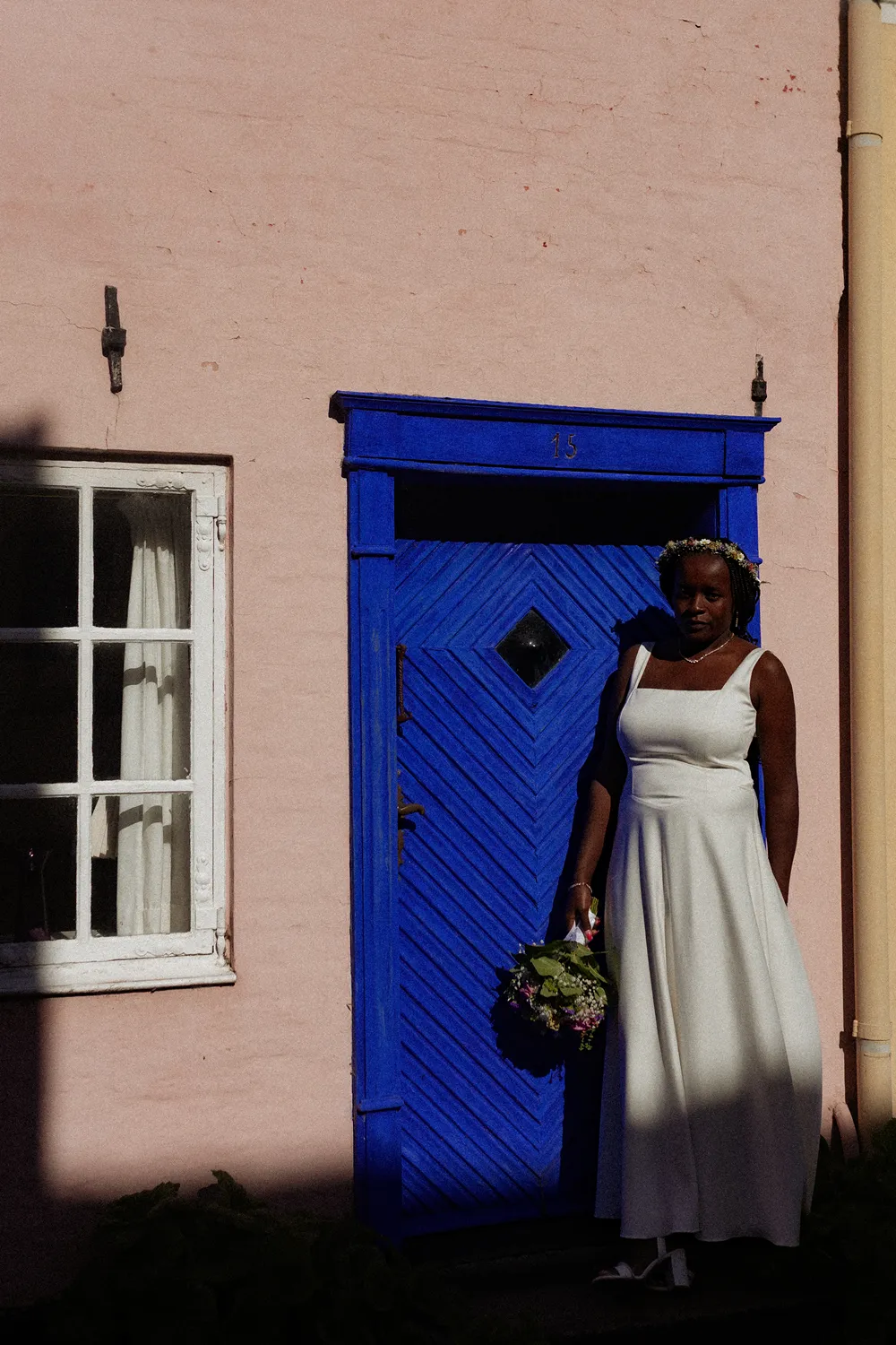 Bride standing near colourful architecture on Ærø is