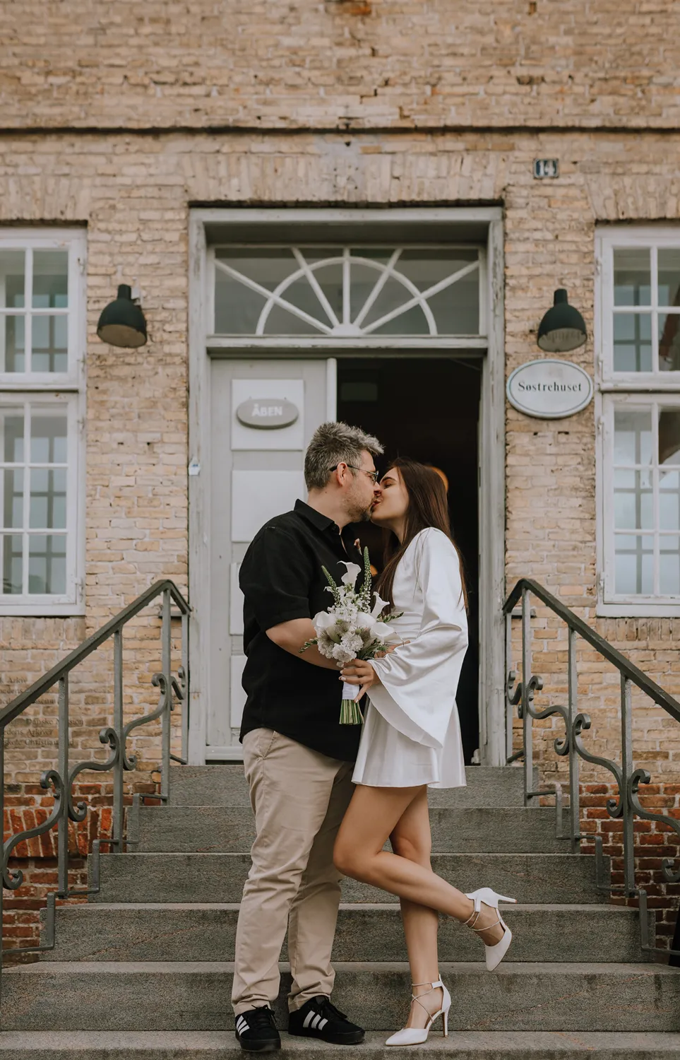 International couple enjoying wedding portraits near Christiansfeld after their Danish wedding ceremony