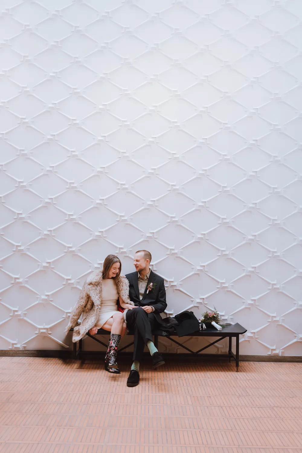 Bride and groom sitting together inside Odense City Hall before their intimate wedding ceremony in Denmark.