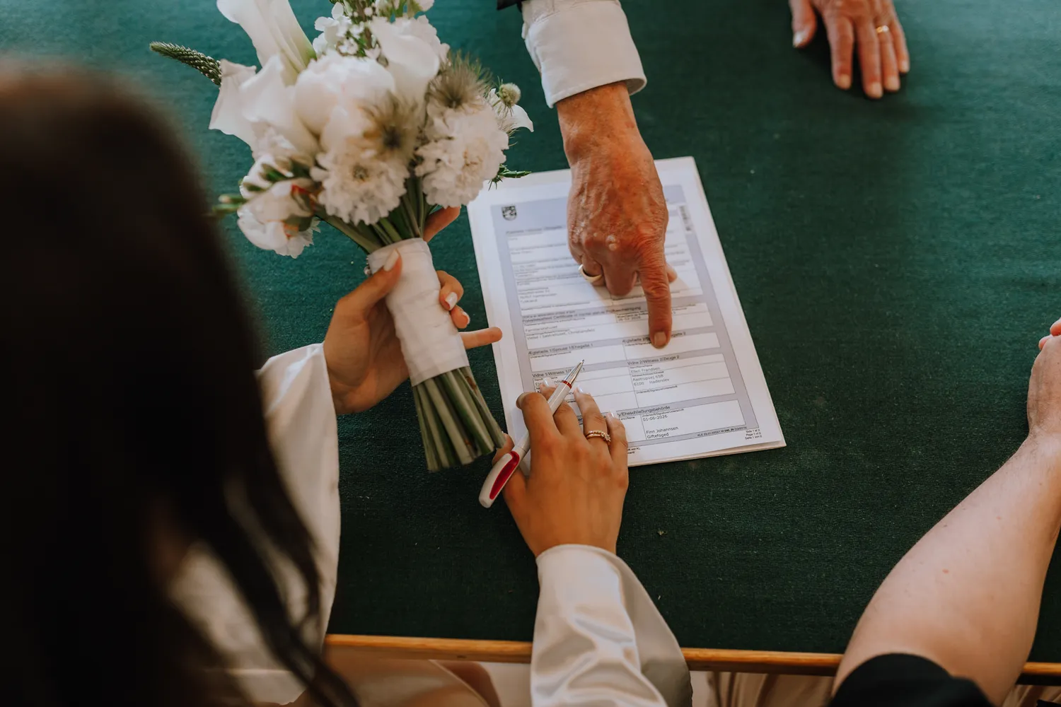 International couple signing marriage documents in Denmark
