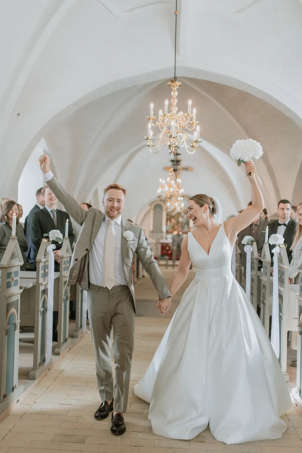 Bride and groom exiting church after timeless Danish wedding ceremony