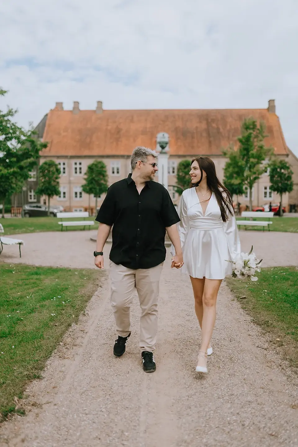 Bride walking through the historic streets of Christiansfeld with her wedding bouquet