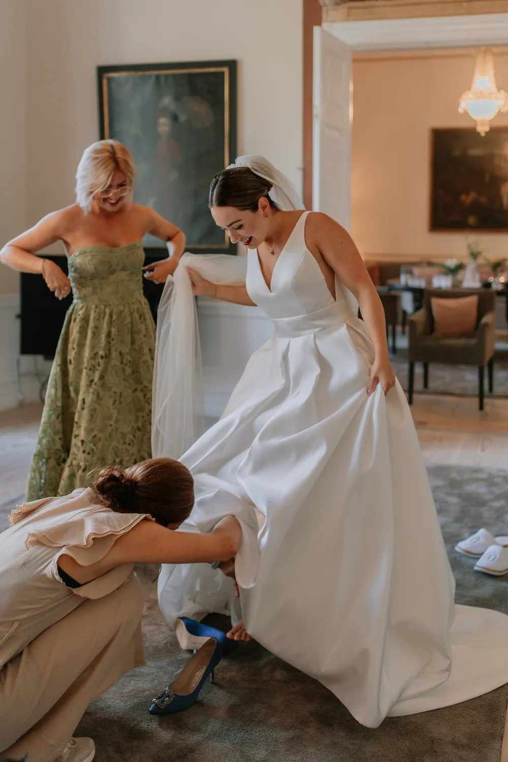 Bride getting dressed with family before Danish castle wedding ceremony