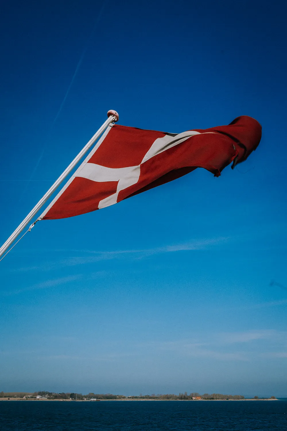 Danish flag waving during ferry journey to Ærø island in Denmark.
