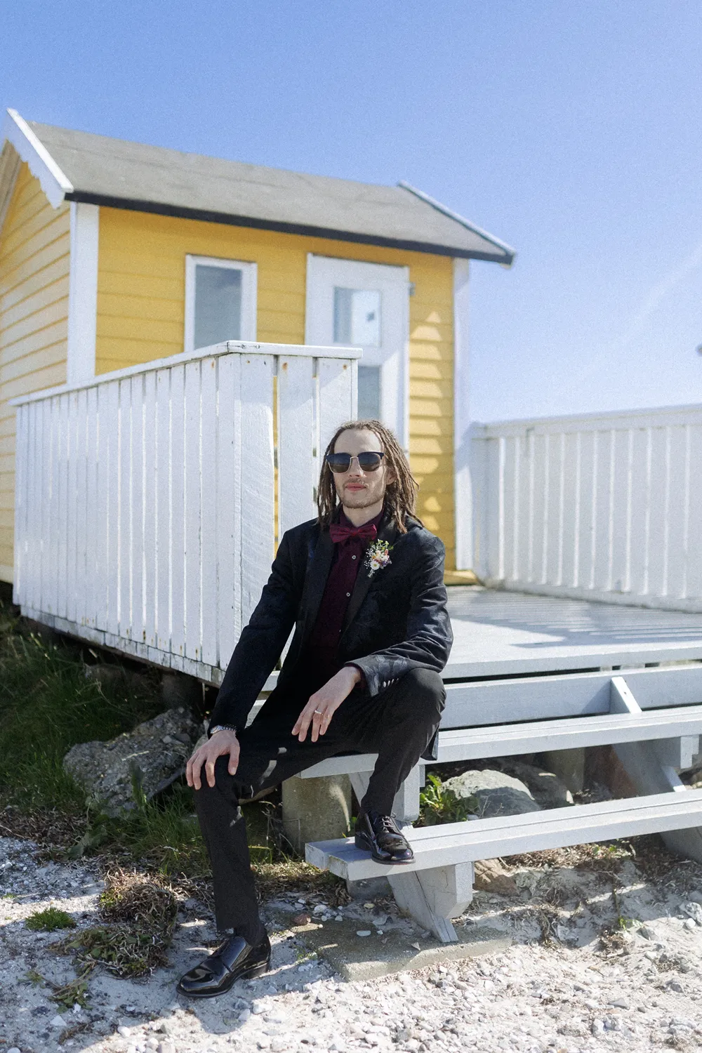 groom beside historic yellow house in Ærøskøbing.