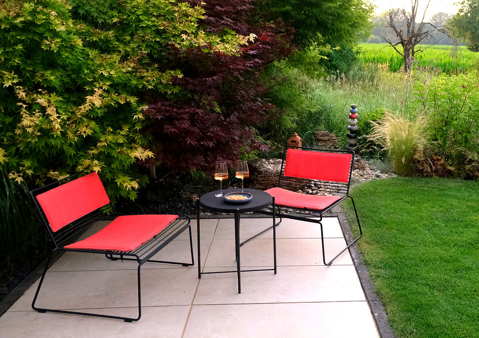 terrasse mit 2 roten Stühlen, Tisch und Weingläsern