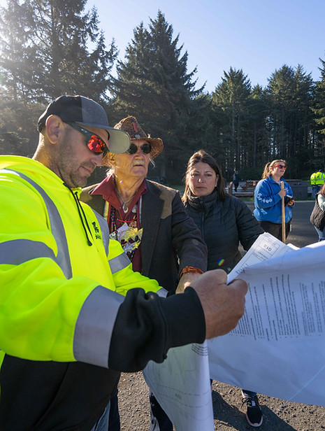 A photo of Nate Clausen reviewing construction plans with a local tribe in Coos Bay, Oregon