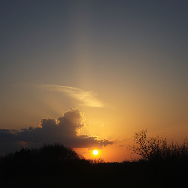 beautiful image or a sunset with the light peeking through the sky.jpg