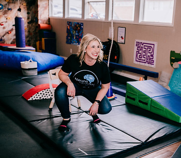 Therapist guides a child through a fun obstacle course to improve coordination and motor skills