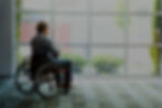 man in wheelchair looking outsite window