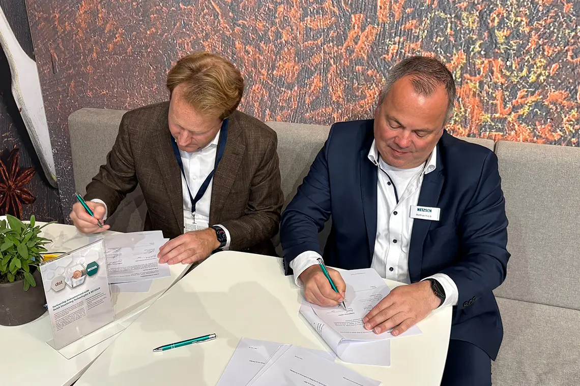 Julian Lekner of DST and Matthias Kapp of NETZSCH signing the strategic partnership agreement at interpack 2026.