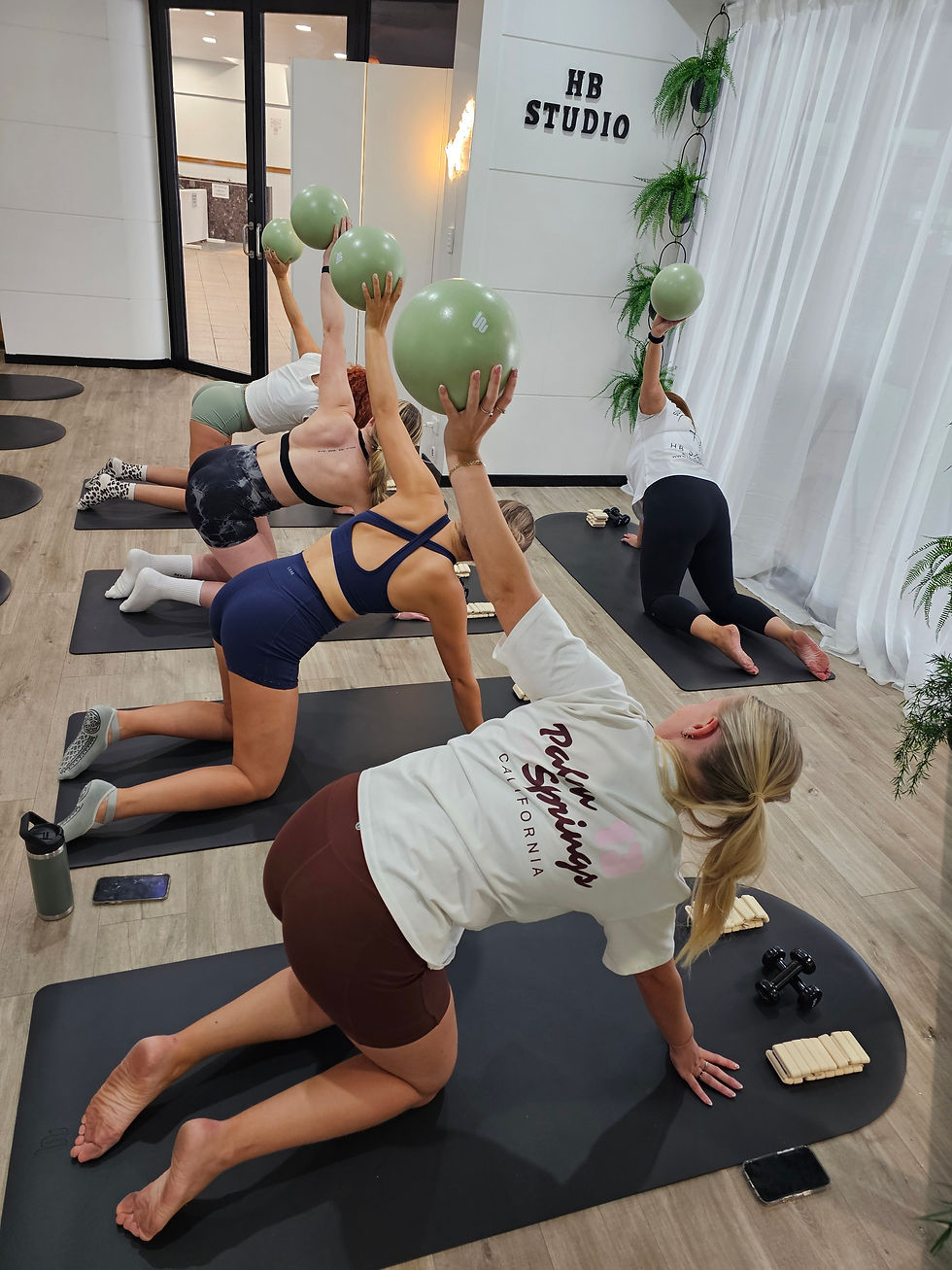 Group of women exercising with balls on mats at HB Studio