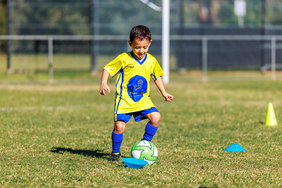 A kid playing and kicking a ball during soccer session at Kick Start FC in Chipping Norton