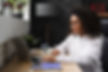 A woman in glasses types on her laptop, illustrating the quality and engagement of LA-HFSI's instructor-led online fire safety training sessions.