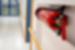 A fire extinguisher mounted on a hallway wall, ensuring safety in healthcare facilities.
